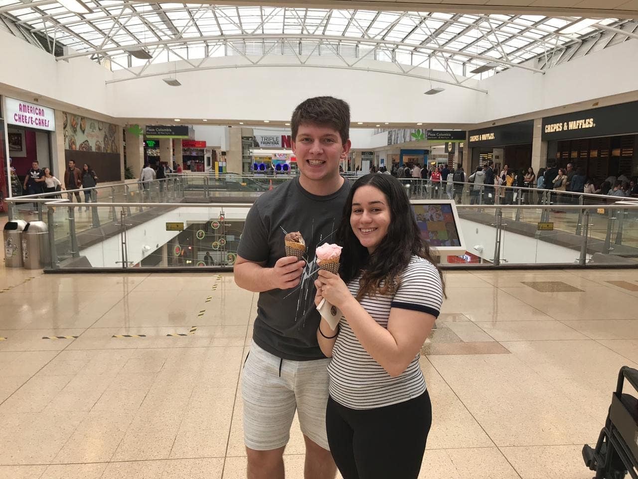Sthephany and Seth smiling with ice cream cones inside a Colombian shopping center