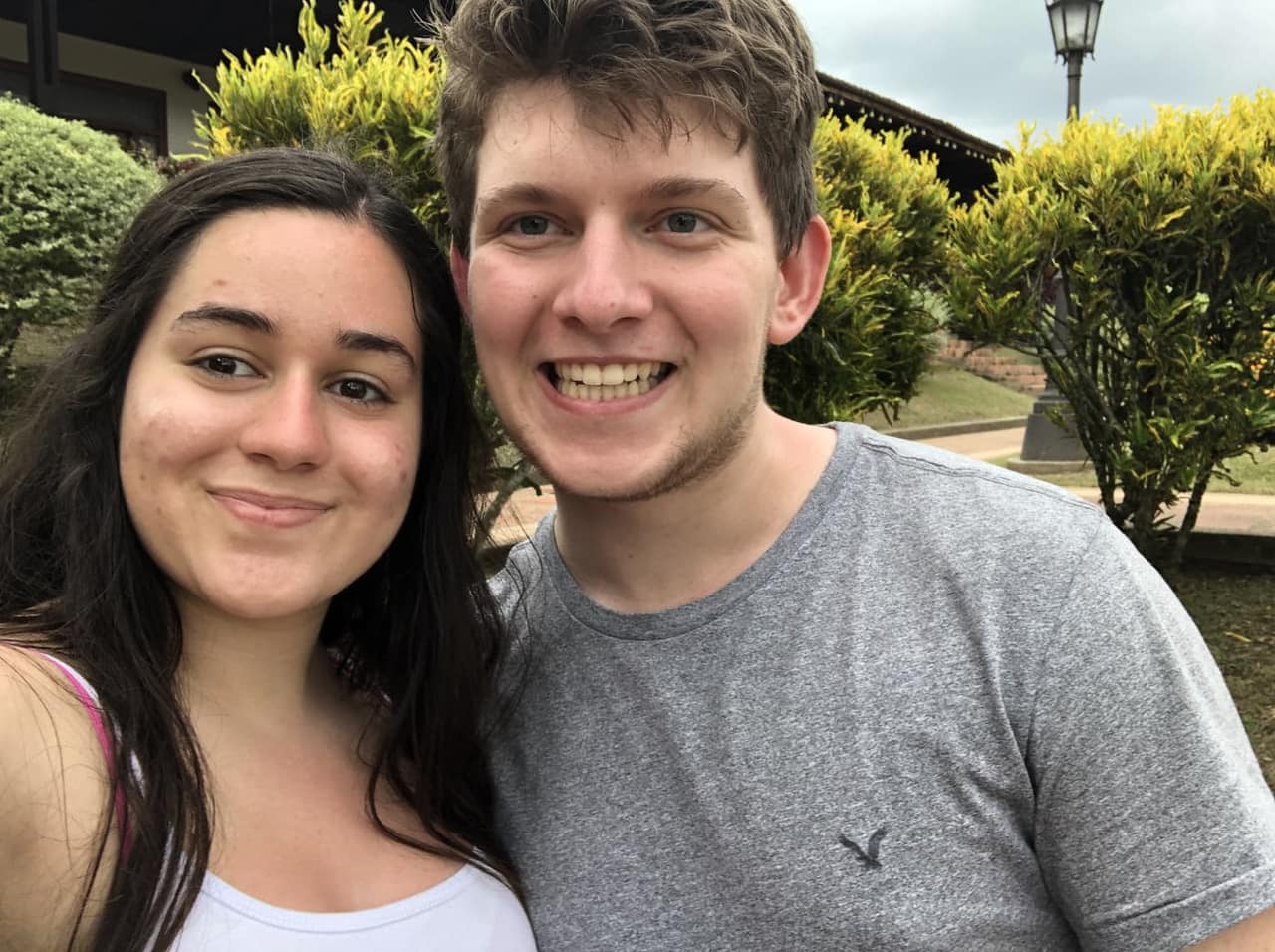 A close-up selfie of Sthephany and Seth smiling in a garden in Colombia